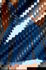 Close-up of back zipper detail and structured flare in deep blue denim