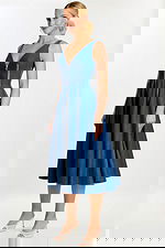 Side angle showing the flared A-line skirt and zippered seams of the denim dress