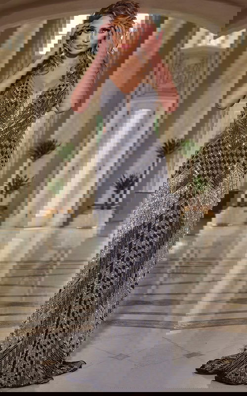 Model wearing Jovani 44723 black dress with deep V-neckline and intricate beadwork, front view.