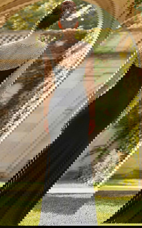 Back view of fitted gown with sheer beaded long sleeves, smooth skirt, and elegant floor length silhouette