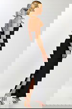 Side back view showing slit and sleek silhouette of black formal dress