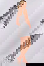 Side-back angle of off white lace mini dress featuring fitted bodice and scoop back