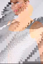 Close-up of bodice showing floral lace texture and subtle beading on neckline