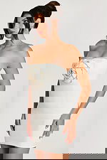 Angled view of strapless off-white cocktail dress with crystal rose