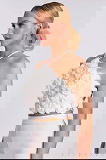 Side view of 3D floral halter crop top with sculpted rose details