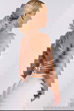 Angled view of white rose appliqué halter top with tie-back