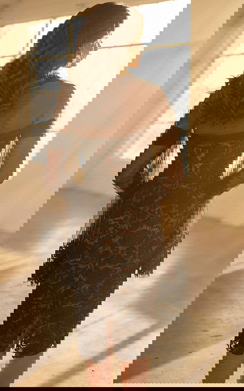 Back view of strapless lace dress with sheer overlay and center slit