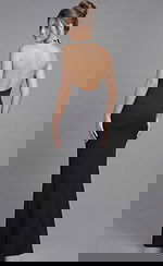 Back view of a fitted halter gown with open back and smooth floor length silhouette