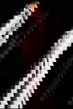 Off shoulder satin gown with feather trimmed sleeves and side ruffle detail