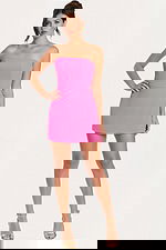 Woman wearing a strapless hot pink romper dress with straight neckline and fitted bodice.