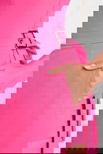 Detailed close-up of gold buckle, waistline, and hand-in-pocket design on hot pink romper.