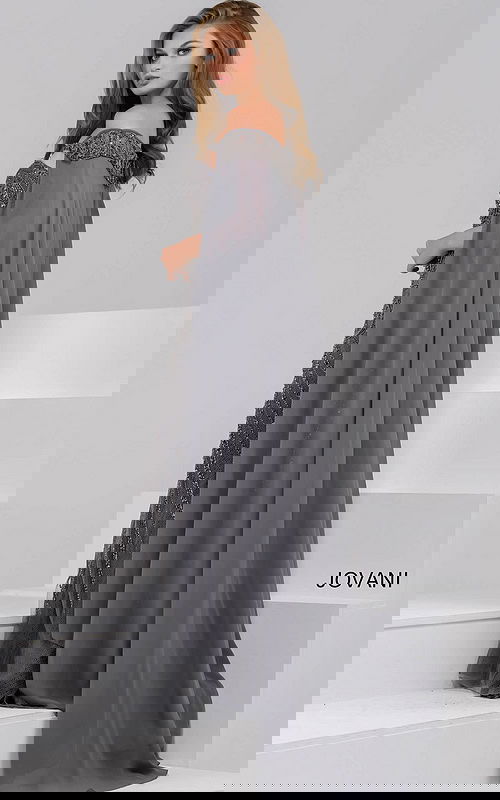 Model wearing Jovani 45566 gray gown with a view of the back and cape-like sleeves.