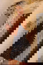 Back view of fitted dress with open back and black floral appliqué