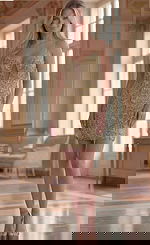 Jovani 45603 gold beaded mini dress with deep plunging illusion neckline, spaghetti straps, and sheer mesh cutout accents, styled with nude heels in an elegant ballroom setting.