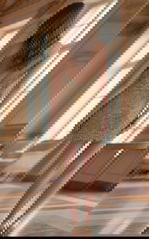 Back view of Jovani 45603 gold beaded mini dress showing low V-back with thin spaghetti straps, zipper closure, and allover floral bead embellishment on sheer mesh.