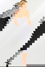 Back view of sleek black midi dress with slit and zipper closure