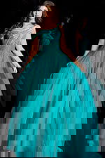 Sparkling formal dress featuring asymmetrical neckline and cascading back drape