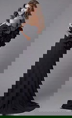 Back view of Jovani 45653 black mermaid gown showcasing voluminous sculptural ruffle off-the-shoulder sleeves, open back, and sweeping train.