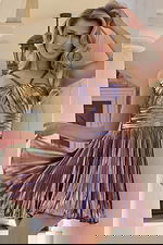 Woman wearing metallic halter mini dress with pleated skirt