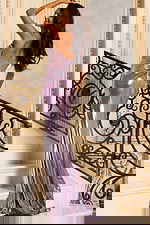 Long shiny evening gown featuring structured bodice and draped back