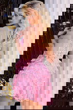 Back view of pink corset dress with sheer panels and ruffles