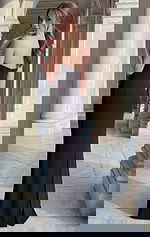 Side angle of strapless black column gown with floor length hem