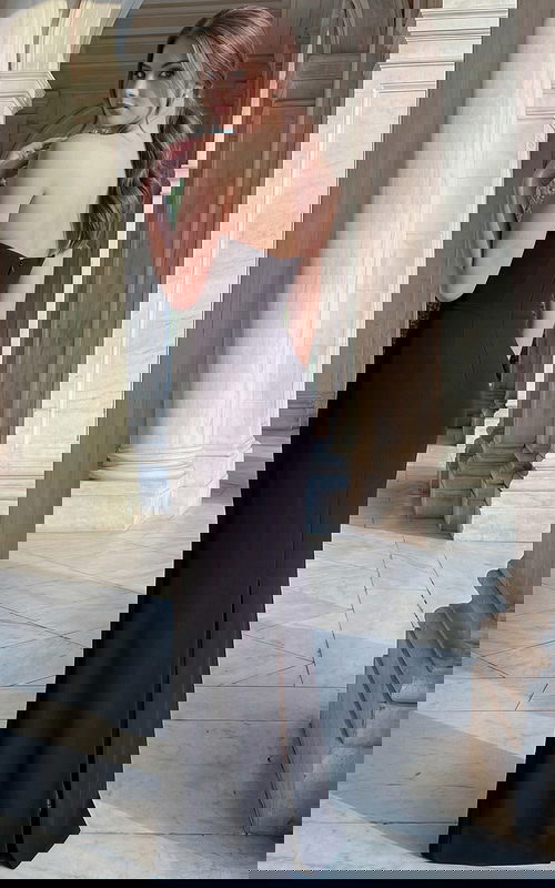 Side angle of strapless black column gown with floor length hem