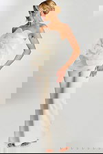 Woman wearing off-white strapless jumpsuit with large floral applique