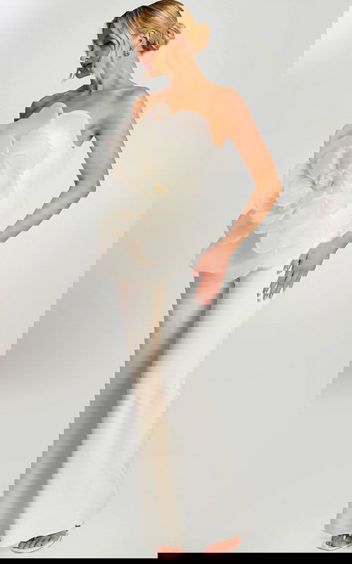 Woman wearing off-white strapless jumpsuit with large floral applique