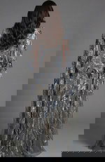 Back view of fitted sequin gown with flowing sheer cape detail