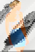 Back view of denim two-piece dress with lace-up closure and beaded flowers