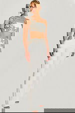 Close-up of beaded floral crop top with asymmetrical strap on ivory pantsuit