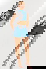 Angled view of embellished denim crop top and shorts