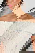 Close-up of floral lace texture and fold-over neckline on off-white dress