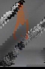 Back view of a fitted halter gown with open back and beaded fringe accents