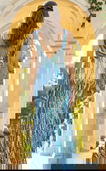 Back view of fitted beaded gown with deep V back, sleeveless cut, and flowing floor length silhouette