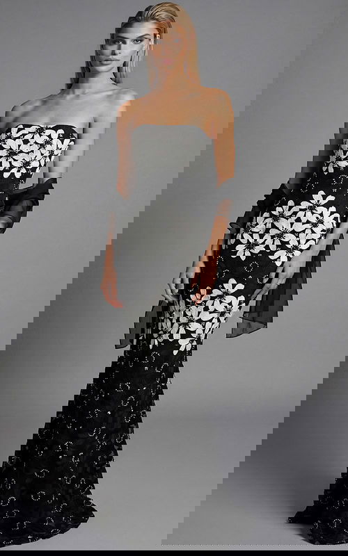 Front view of a strapless black floral brocade column gown