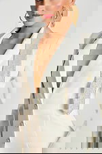 Close-up of white pants showing satin side stripe and smooth fabric texture