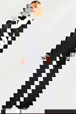 Front view of black velvet jumpsuit with white sculptural ruffle detail