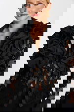 Close-up of sheer floral lace blouse with tiered ruffles and glossy black buttons