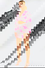 Side angle of cropped tweed jacket and belted mini skirt with metallic buckle