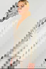 Angled back view showing panel details and sculpted silhouette of off-white blazer