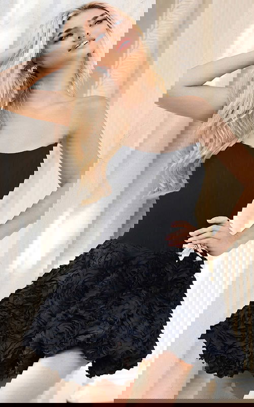 Model wearing black corset dress with structured top and floral skirt