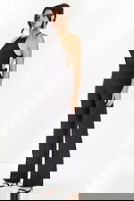 Side angle of sleeveless black jumpsuit with fitted bodice and open sides