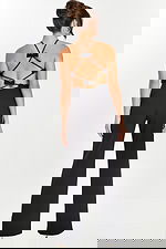 Back view of black jumpsuit featuring crisscross straps and bow accents