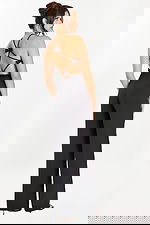 Back-side angle of open-back black jumpsuit with bow details