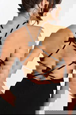 Close-up of strappy open back on black jumpsuit with multiple bows