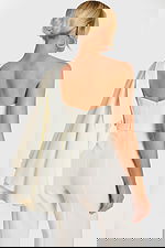 Back angle of cape-style bridal outerwear over tailored jumpsuit