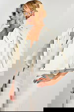 Front view of strapless V-notch white jumpsuit with jacket in hand