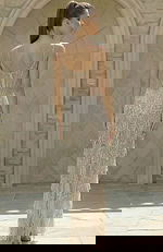 Back view of beaded gown with sheer corset detail and layered fringe skirt